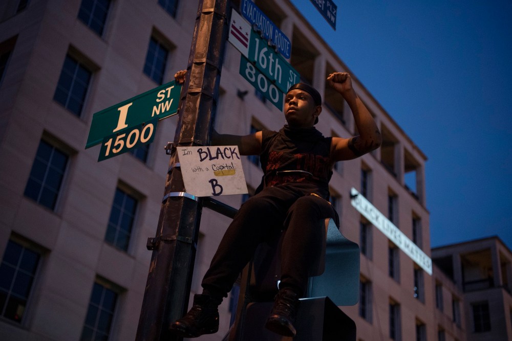 États-Unis - 06 juin: un jeune homme est assis au sommet d'un signal de rue sur la section de la 16e rue surnommée Black Lives Matter Plaza après une journée de manifestations pour honorer George Floyd et les victimes d'injustice raciale le samedi 6 juin 2020 (photo de Tom Williams / CQ Roll Call / Sipa USA) Pas d'utilisation au Royaume-Uni. Pas d'utilisation en Allemagne.