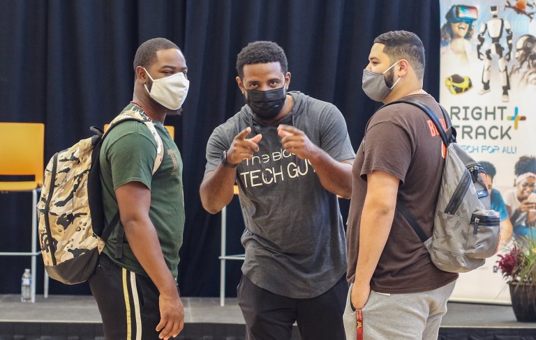 Trois hommes debout ensemble, l'un regardant la caméra, dans l'auditorium du comté de St Paul Ramsey