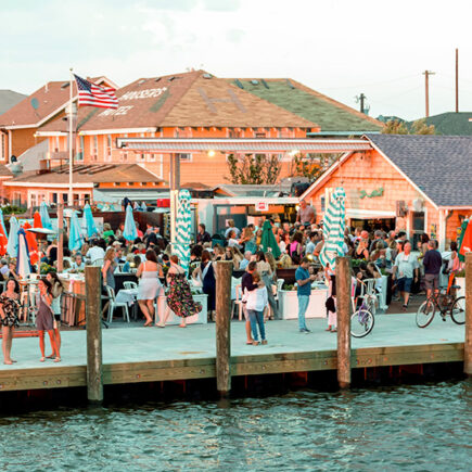 Photo of long island restaurant near the ocean and bay with people having food and cocktails.