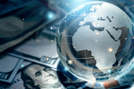 Photo: Crystal globe on many currency.