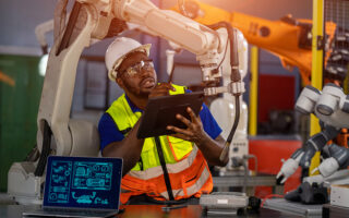Decorative Image: Engineers programming automated robot during checking the robot coding.