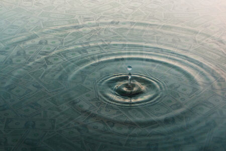 Decorative image: Ripple of water over dollar bills