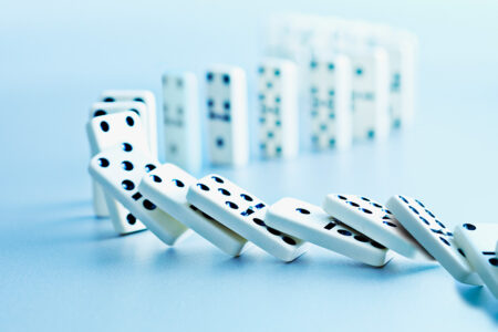 Photo: dominoes spilling on a blue background.