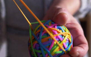 Decorative image: Man pulling an orange rubber band, holding a rubber band ball