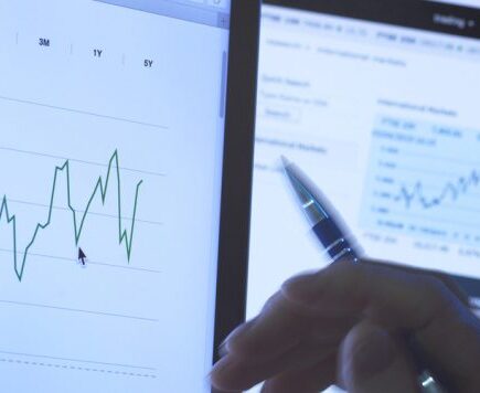 Homme regardant les cours des actions sur un écran d’ordinateur