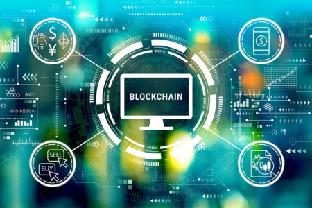 Decorative image: blockchain with spokes including cryptocurrency, mobile $, buy/sell icons. Cryptocurrency fintech theme with big city lights at night.
