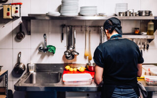 Photo: Immigrant cook working alone in a kitchen