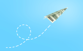 Photo: Dollar paper airplane on blue background