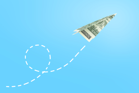 Photo: Dollar paper airplane on blue background