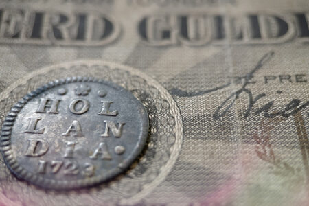 Photo: Old Dutch coins from the province of Holland with ancient Dutch banknotes.