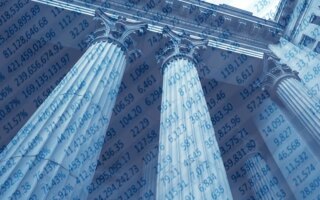 Classic bank building with columns overlaid with balance sheet numbers.