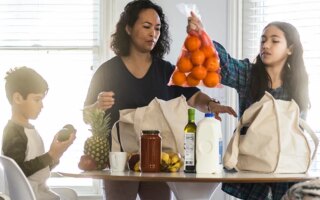 Mother and children unloading groceries