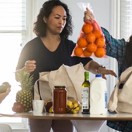 Mother and children unloading groceries