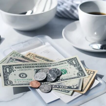 Image of a cafe receipt with U.S. money on top to pay the bill.