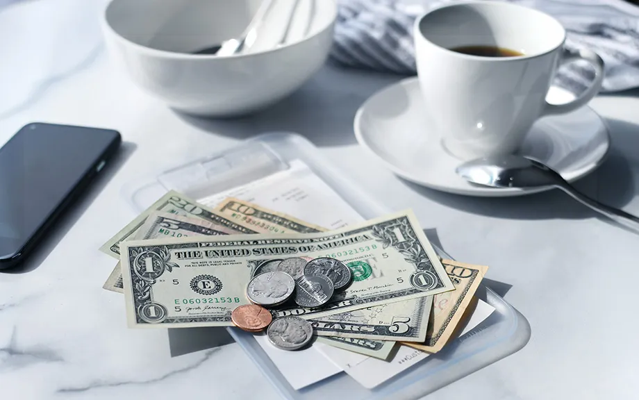 Image of a cafe receipt with U.S. money on top to pay the bill.