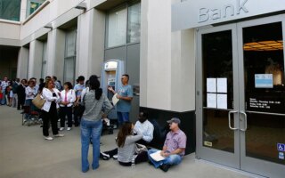 Photo of a long line of customers waiting to get into a Bank, open for the first time since the federal government takeover due to the bank