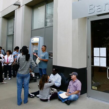 Photo of a long line of customers waiting to get into a Bank, open for the first time since the federal government takeover due to the bank