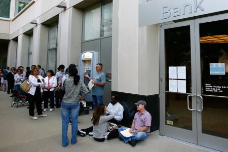 Photo of a long line of customers waiting to get into a Bank, open for the first time since the federal government takeover due to the bank