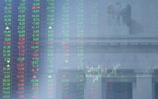 Decorative image of stock price board superimposed on the Federal Reserve building in Washington, D.C.